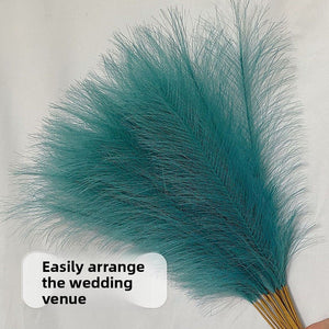 Artificial reed pampas plumes shown in several colors held against a plain background