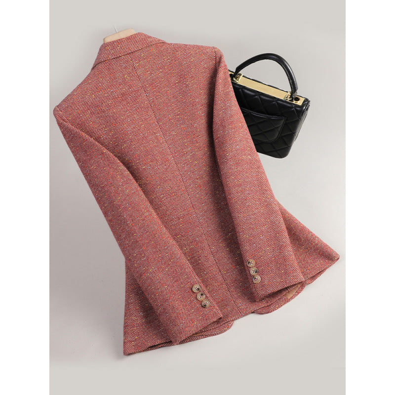 Orange red flecked tweed blazer on a hanger, back view with a centre seam and three cuff buttons