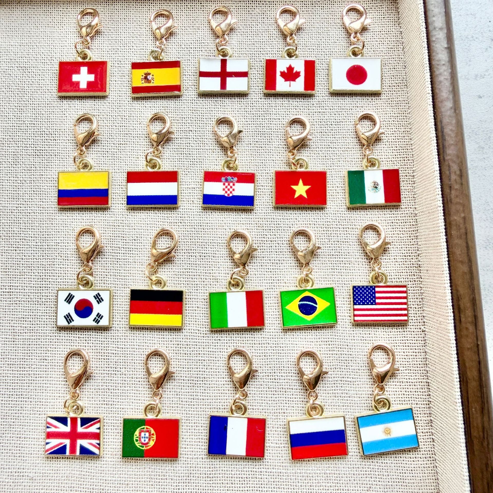 Twenty enamel country flag keychain charms shown with gold tone lobster clasps
