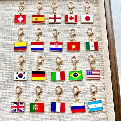 Twenty enamel country flag keychain charms shown with gold tone lobster clasps