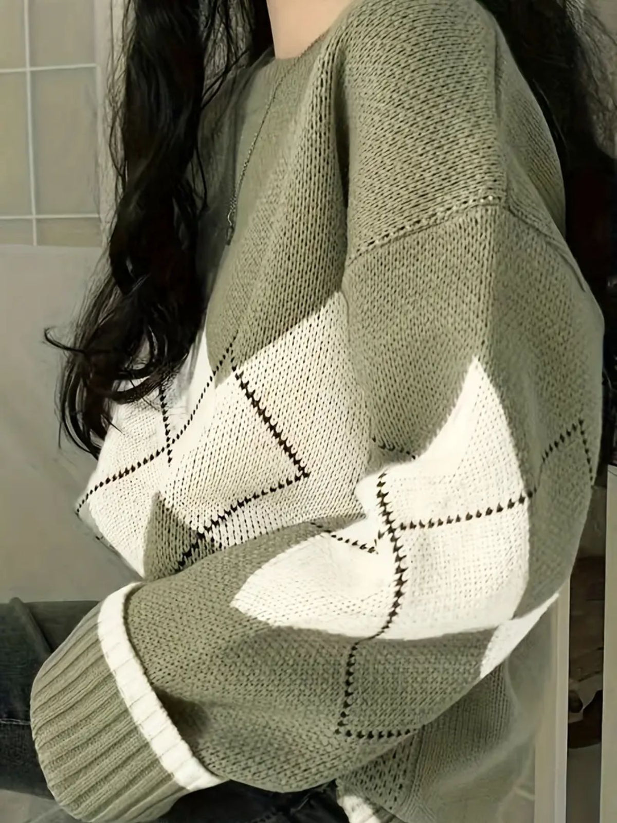 Matcha green knit sweater with cream argyle diamonds, side view showing the dropped shoulder and ribbed cuff