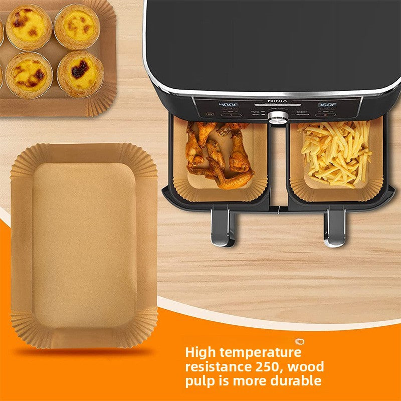 Rectangular wood pulp liners in a dual zone air fryer holding chicken wings and fries