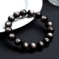 Natural obsidian bead bracelet showing gold sheen double eye reflection detail