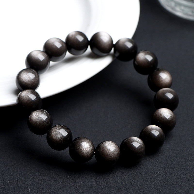 Natural obsidian bead bracelet showing gold sheen double eye reflection detail