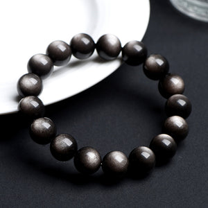 Natural obsidian bead bracelet showing gold sheen double eye reflection detail