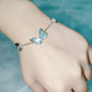 Close view of the blue enamel butterfly pendant on a silver tone chain