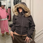 Model wearing the brown cropped fur trimmed hooded zip jacket with a tan plush fur hood and chest zip pockets