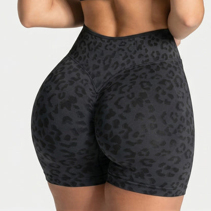 Back view of black seamless high waist yoga shorts with a tone on tone leopard print and ribbed waistband