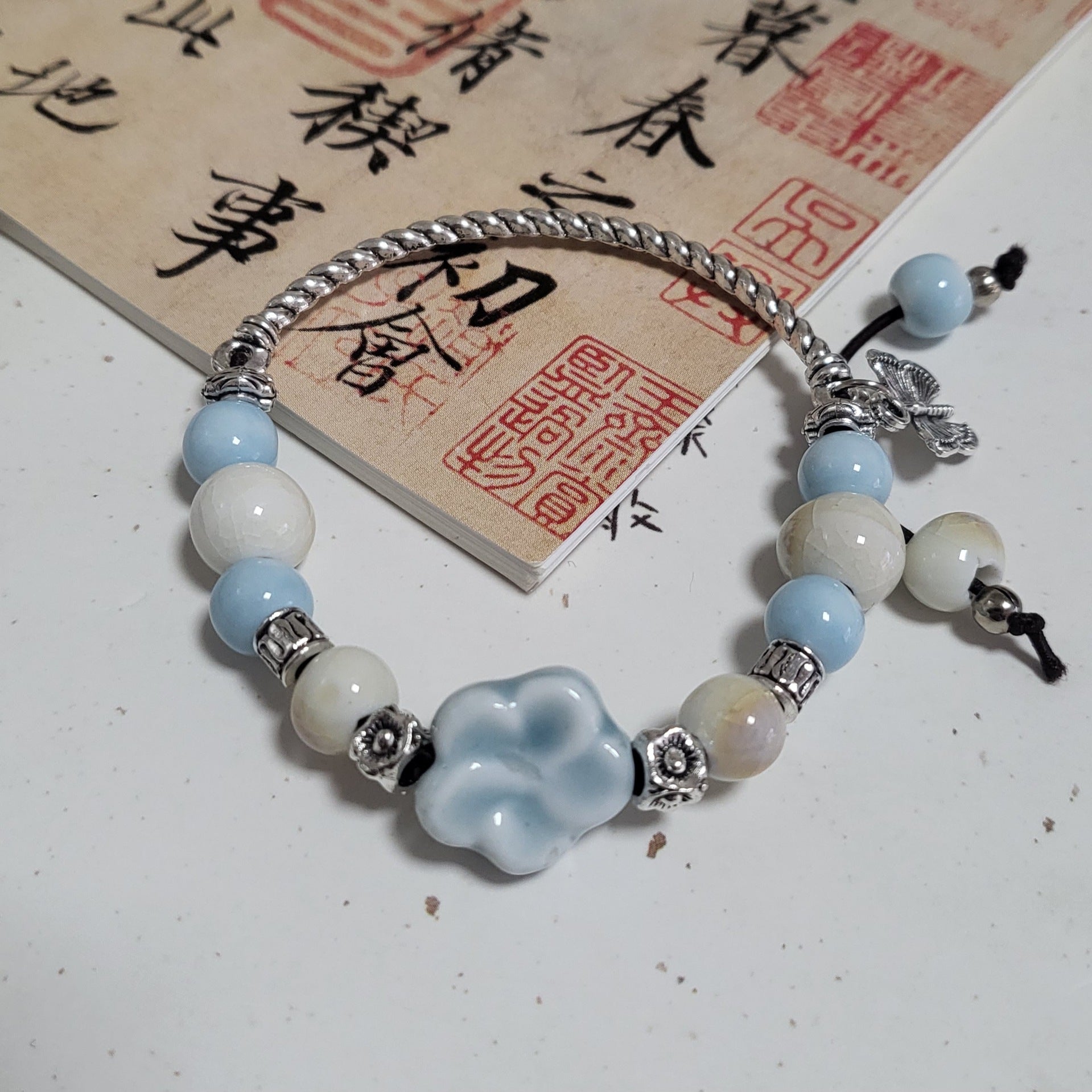 Ceramic beads styled into a bracelet stack with metal spacers
