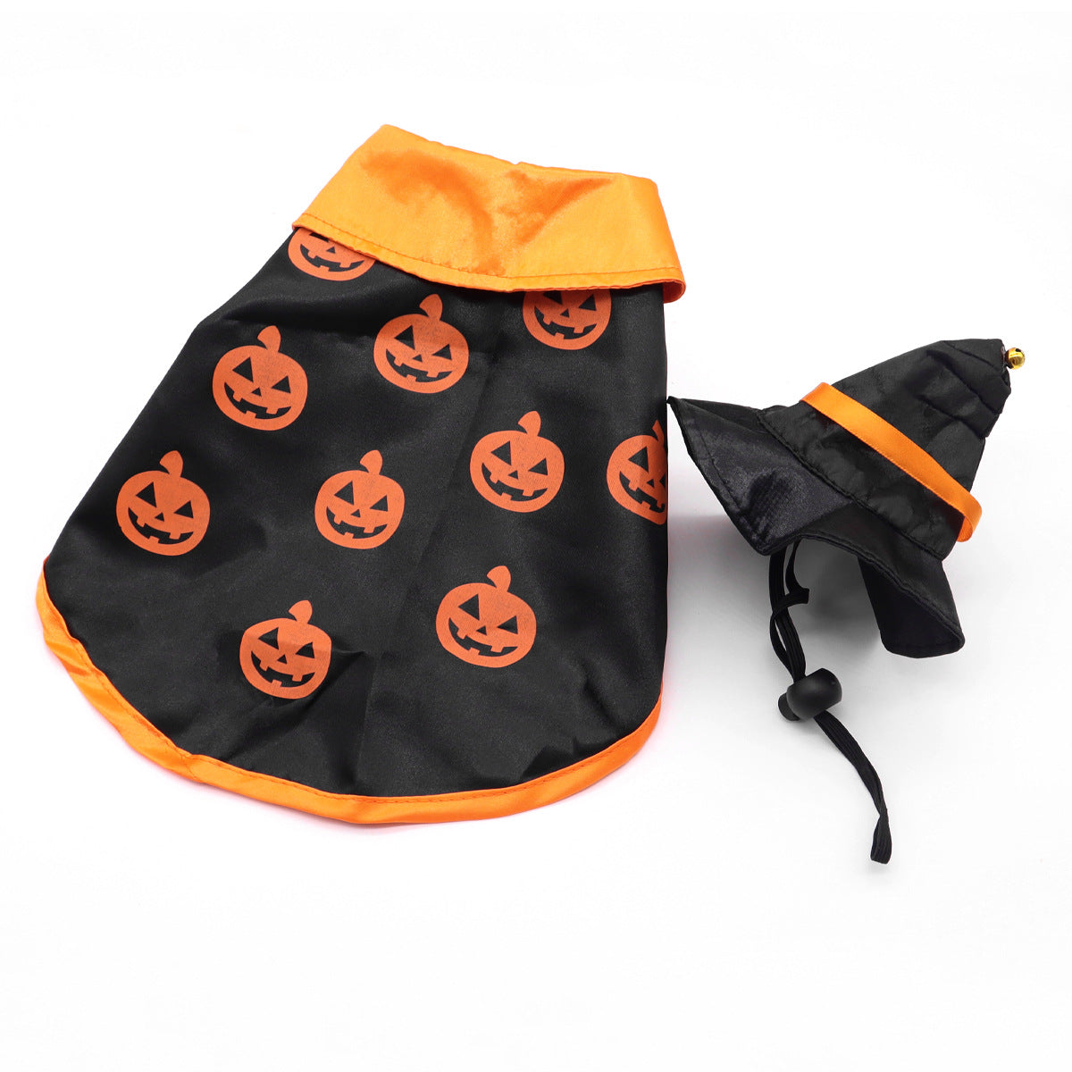 Orange trimmed black pet cape printed with pumpkin faces beside a black and orange witch hat