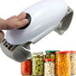 A hand holds a white electric jar opener above a row of pickle, olive, garlic and corn jars