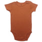 Folded baby short sleeve cotton bodysuit with shoulder snap shoulders on a plain background
