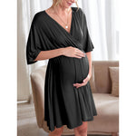 Maternity wrap dress worn on model with both hands cradling the pregnancy bump