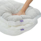Hand pressing into a gray puff grid bed pillow to show how the fill springs back
