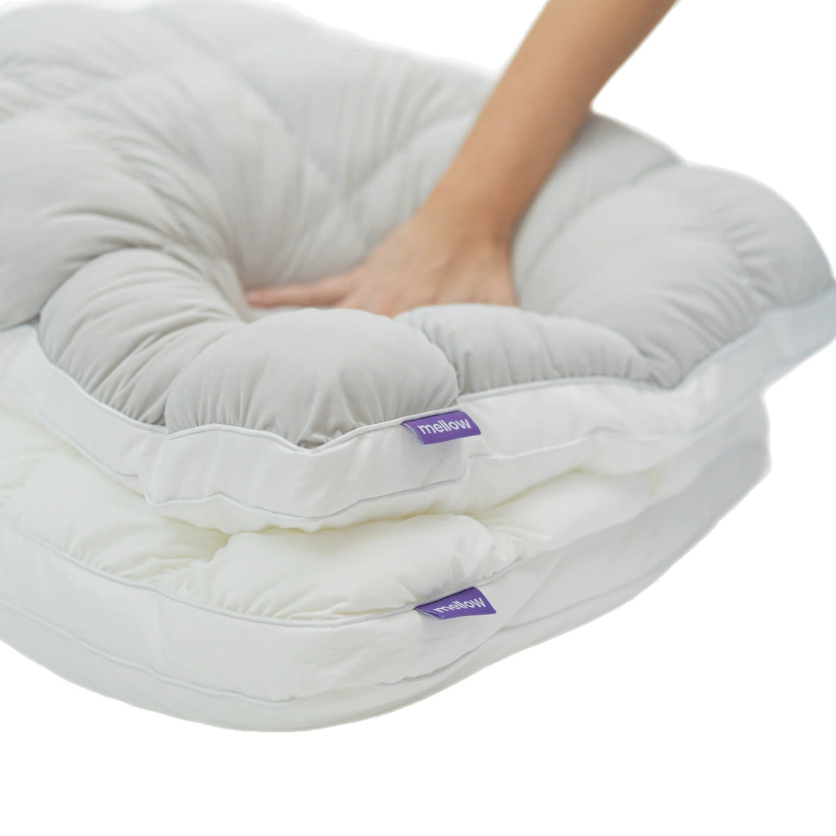 Hand pressing into a gray puff grid bed pillow to show how the fill springs back