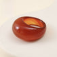 Red agate stone ring carved solid on a soft plain background