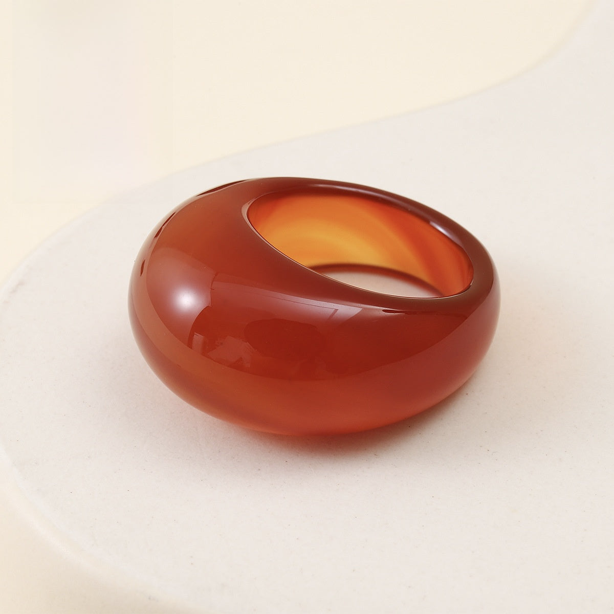 Red agate stone ring carved solid on a soft plain background