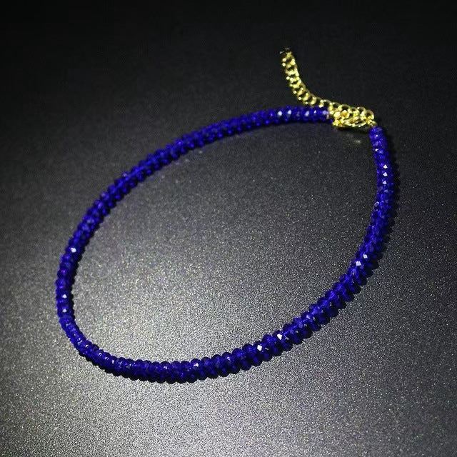Deep blue strand of small faceted glass beads with a gold tone extender chain