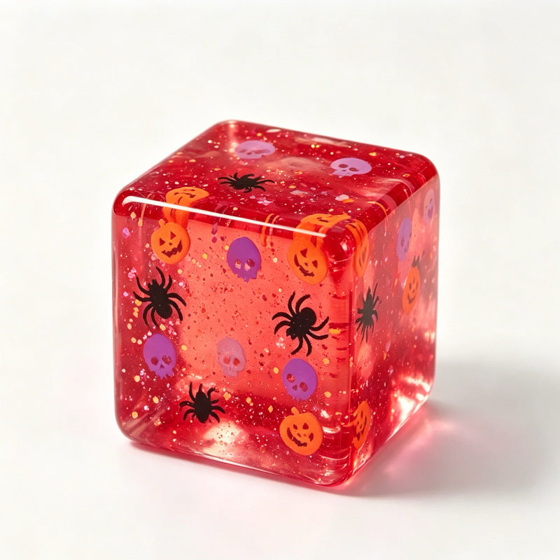 Glitter filled Halloween squishy cube printed with pumpkins skulls and black spiders
