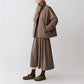 Brown wool blend down jacket with built in scarf collar and snap front, side view on a model