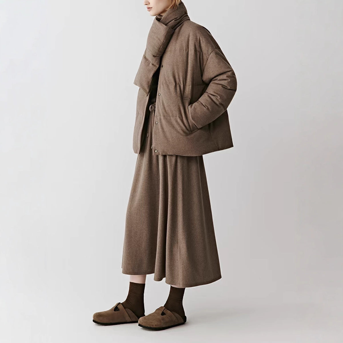 Brown wool blend down jacket with built in scarf collar and snap front, side view on a model