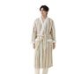 Man on a white background in an off-white striped fleece robe with olive green and red stripes and a belt