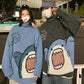 Couple at night wearing blue and charcoal knitted shark sweaters with high turtlenecks