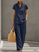 Navy short-sleeve stand-collar top and wide-leg pants set worn front view with a tote