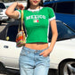 Short sleeve crop country tee flat lay on plain background
