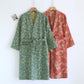 Emerald green and leaf red cotton gauze kimono robes on hangers showing the wrap front and tie belts