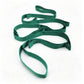 Yoga stretch strap used for a standing leg and shoulder stretch on a mat