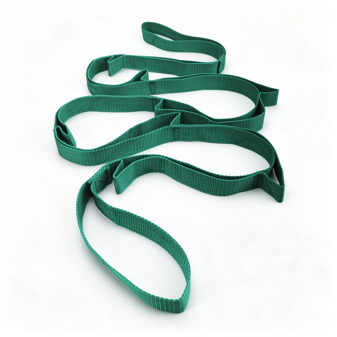 Yoga stretch strap used for a standing leg and shoulder stretch on a mat
