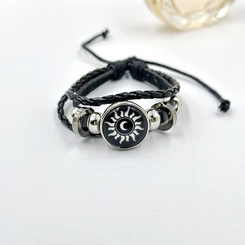 Braided cord charm bracelet close up on the silver tone frame around the charm