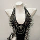 Front view of spiked faux leather punk vest with skull heads at the collar and boned bodice