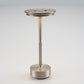 Silver table lamp with a knurled grip band on the slim stem and a round base on a light background