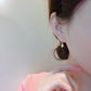 Ear cuff resting on its small velvet jewelry pouch