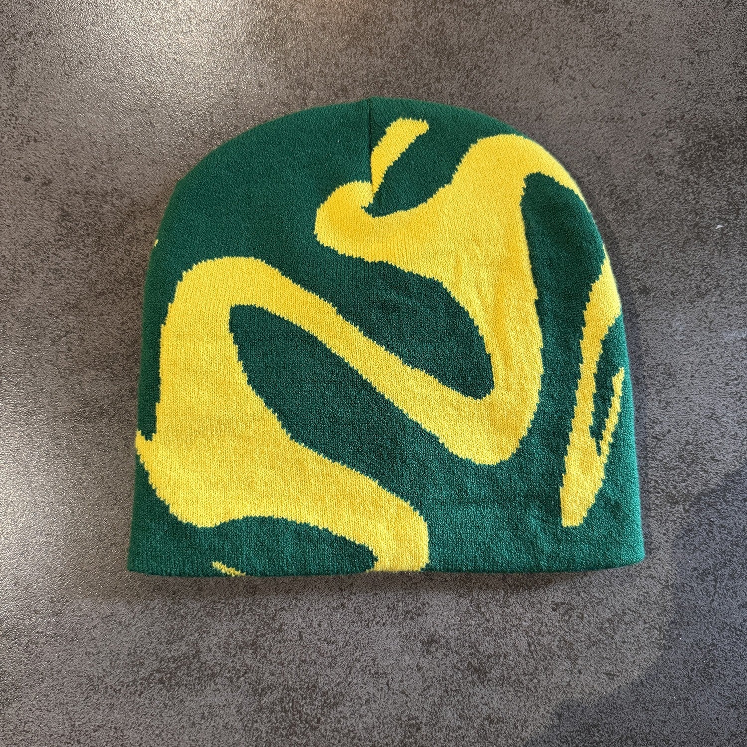 Green brimless knit beanie with a folded edge that sits over the ears