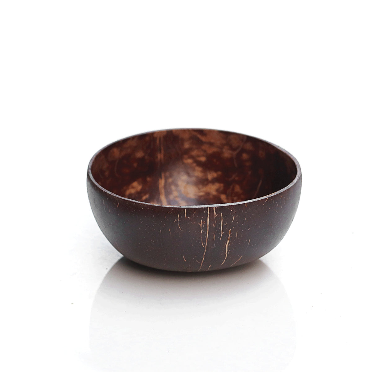 Coconut shell bowl holding a smoothie bowl with a wood spoon resting inside