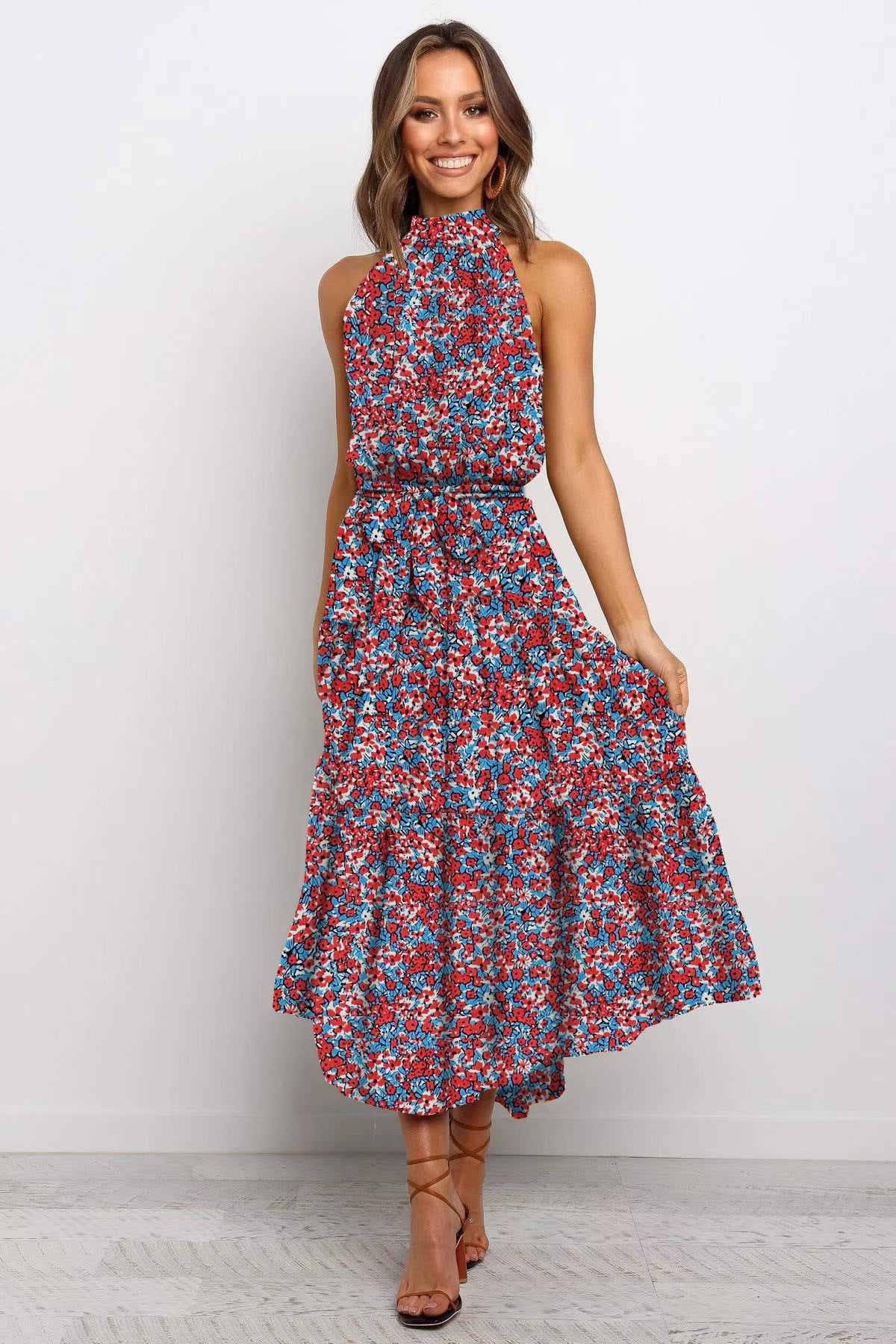 Blue and red boho floral halter neck sleeveless tiered swing maxi dress worn by a model