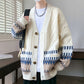Cream cable knit cardigan worn open over a white tee with a chain necklace, jacquard band at the hem and sleeves