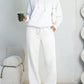 White fleece hooded sweatshirt and wide-leg sweatpants set worn by a model
