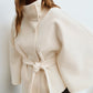 Short cape jacket with cape cut sleeves and a matching self tie belt at the waist
