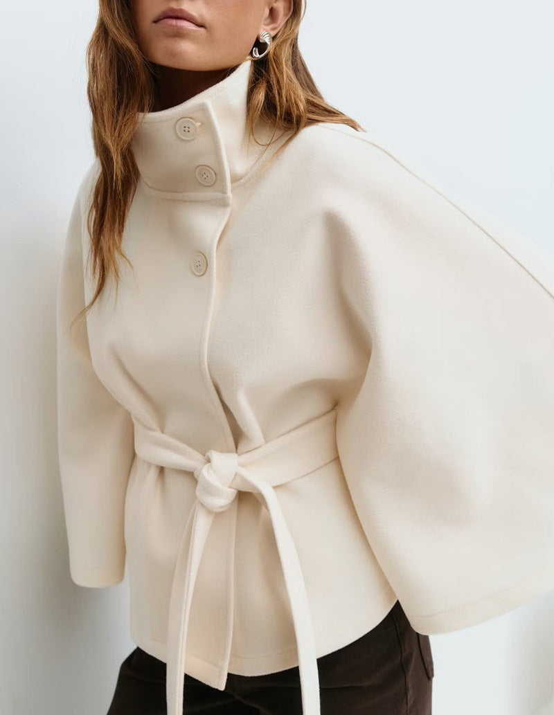 Short cape jacket with cape cut sleeves and a matching self tie belt at the waist