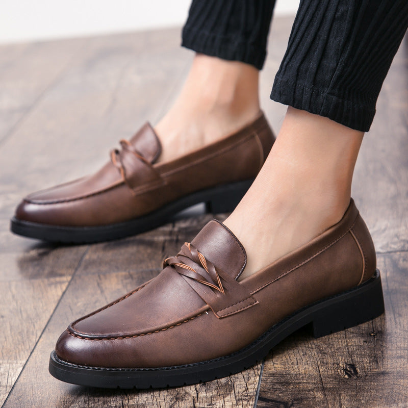 Brown apron toe loafers worn with black trousers on a wooden floor, bare ankles and low block heel
