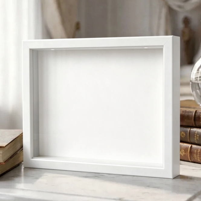 Empty white shadow box frame with a plain white backdrop on a shelf, the Default option without a display