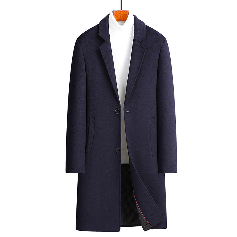 Navy blue single-breasted long coat with notch lapel on a hanger over a white turtleneck, front view