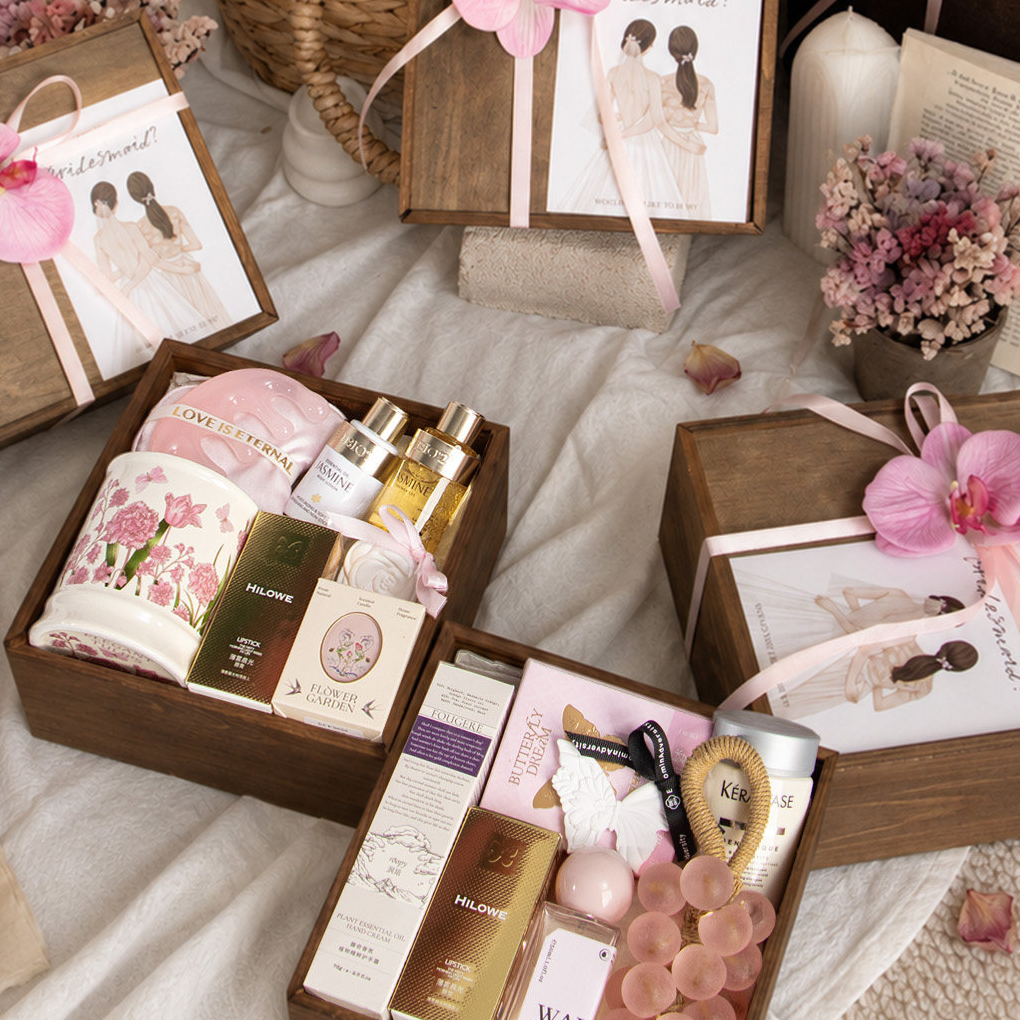 Wooden gift boxes with a pink ribbon and pink orchid flower, one open with a ceramic cup and gifts