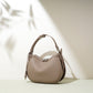 Oak gray taupe pebbled cowhide crescent bag with silver tone sliders and a leather tab at the lower side