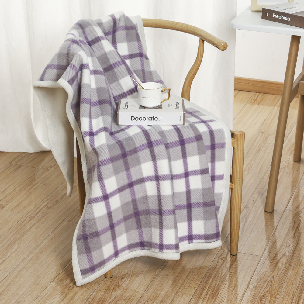 Purple and white plaid coral fleece blanket in 100 x 140 cm draped over a wooden chair