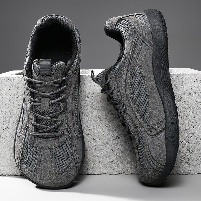 Dark gray mesh lace-up sneakers with matte overlays and a dark flat sole on a concrete block, size 44 option photo
